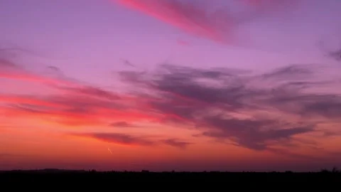 Multi colored sunrise sky sun and light clouds over a field fast time lapse hori Stock Footage 326790881