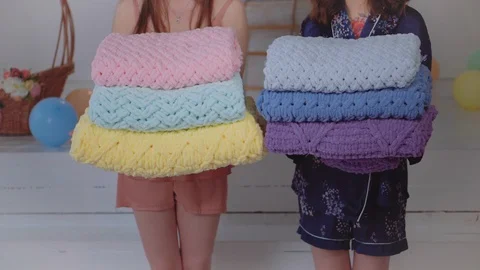 Multi-colored sweaters in the hands of models in pajamas Stock Footage 126664234