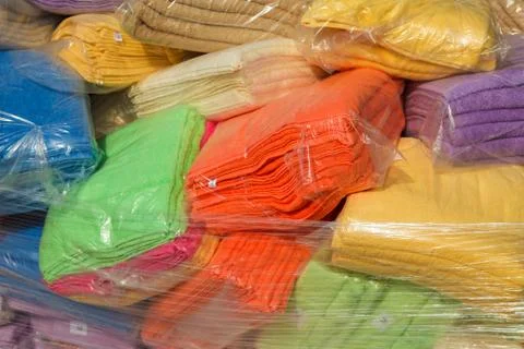 Multi-colored terry towels packed in plastic bags in stock Photos