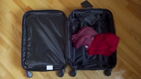 Multi-colored things flying into a suitcase. Collect things for a tourist tri Stock Footage 180681505