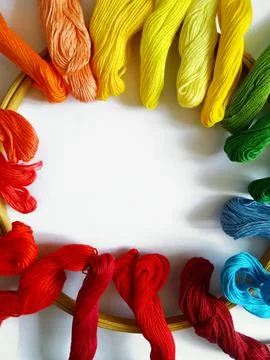 Multi-colored threads for embroidery and a hoop on a white background Stock Photos