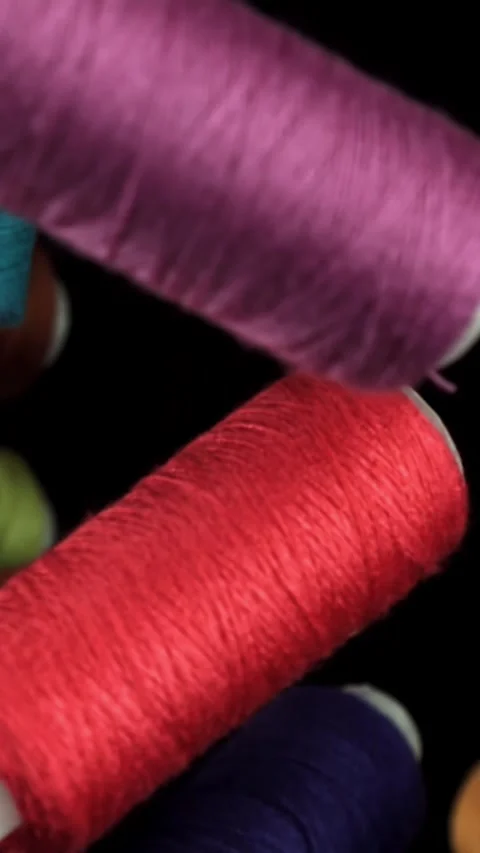 Multi-colored threads fly on a black background. Filmed on a high-speed camera Stock Footage 335378035