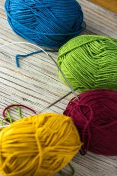 Multi-colored threads for knitting and knitting needles. Selection of colorful Foto stock