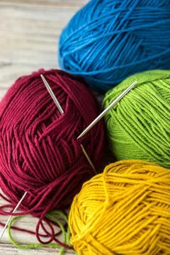 Multi-colored threads for knitting and knitting needles. Selection of colorful Foto stock