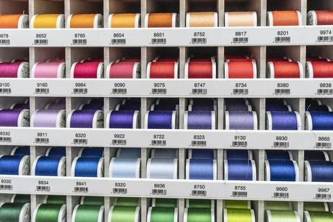 Multi-colored threads on the shop window. Hobby and needlework shop with a Foto stock