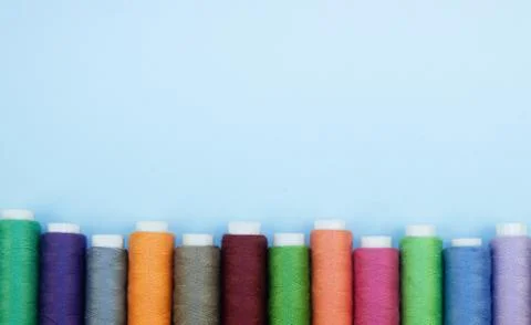 Multi-colored threads in spools, sewing kit, tailor's kit on a light backgrou Stock Photos