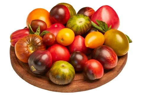 Multi-colored tomatoes: red, yellow, orange, green on a round wooden board .. Stock Photos