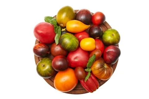 Multi-colored tomatoes: red, yellow, orange, green on a round wooden board .. Stock Photos