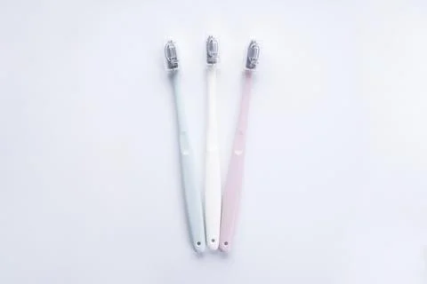 Multi-colored toothbrushes with black bristles on a white background, flat la Stock Photos