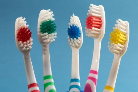 Multi-colored toothbrushes on blue background Stock-Fotos
