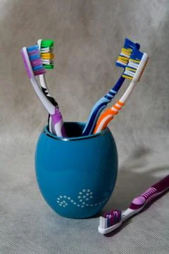Multi-colored toothbrushes stand in a special glass. Stock Photos