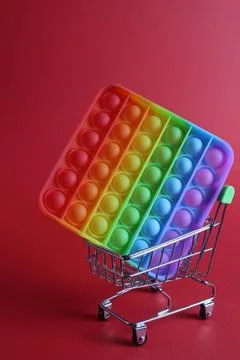 The multi-colored toy is a popit simple dimple anti-stress in a basket of str Stock Photos