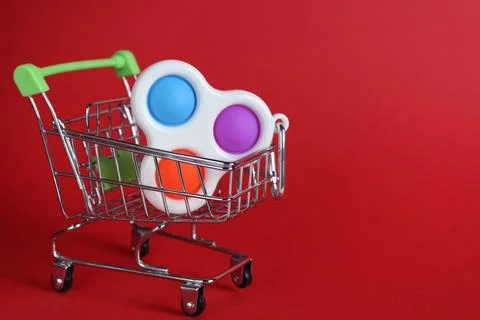 The multi-colored toy is a popit simple dimple anti-stress in a basket of str Stock Photos