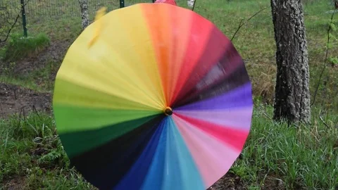Multi-colored umbrella in the open air is spinning in different colors Stock Footage 91055782