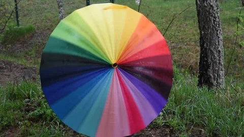 Multi-colored umbrella in the open air is spinning in different colors Stock Footage 91055786
