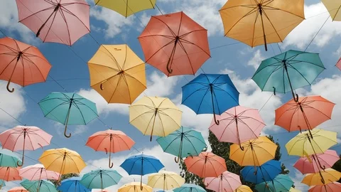Multi-colored umbrellas on a background of blue sky. Video stock 113970206