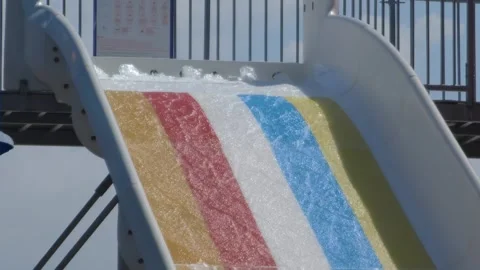 A multi-colored water slide in water park twists and turns, offering vibrant Stock Footage 277182530