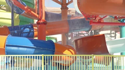 A multi-colored water slide in water park twists and turns. Video stock 287108555