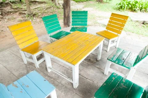 Multi-colored wooden table and chairs. Stock Photos