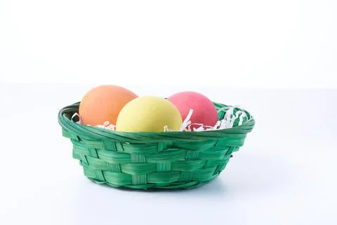 Multi colors Easter eggs in the woven basket isolated on white background wit Stock Photos