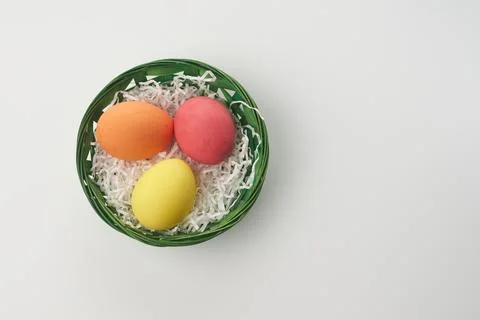 Multi colors Easter eggs in the woven basket isolated on white background wit Stock Photos