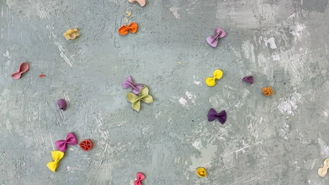 Multi-coloured pasta falling from above on a green background Stock Footage 305899704