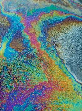 MULTI COLOURED PATTERNS OF OIL FLOATING ON WATER Stock Photos