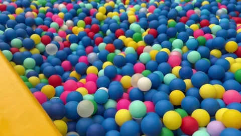 Multi coloured plastic balls in a dry paddling pool in playing centre Stock Footage 311793506