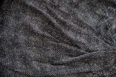 Multi coloured Sequins on Black Fabric. Festive background Stock Photos