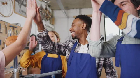 Multi-Cultural Team Of Trainees In Workshop Building Bicycles Giving Each Other Vídeos de archivo 130464934