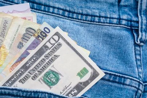 Multi currency banknotes in back pocket of blue jeans Photos
