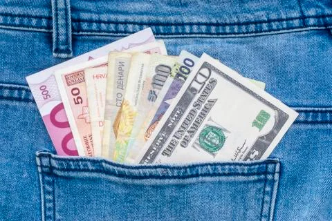 Multi currency banknotes in back pocket of blue jeans 写真素材