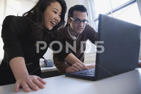 Multi-ethnic businesspeople looking at laptop Stock Photos