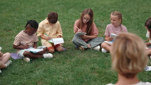 Multi ethnic children enjoying outdoors lesson with teacher Stock Footage