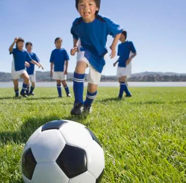 Multi-ethnic children playing soccer Stock Photos