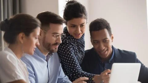 Multi-ethnic colleagues looking on computer screen working together Stock Photos