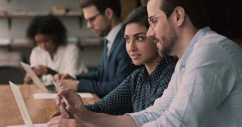Multi ethnic colleagues talking cooperate in coworking office using laptop Stock Footage 144427921