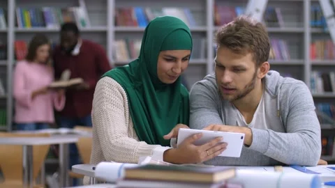 Multi ethnic college students sharing tablet pc Stock Footage 102526420
