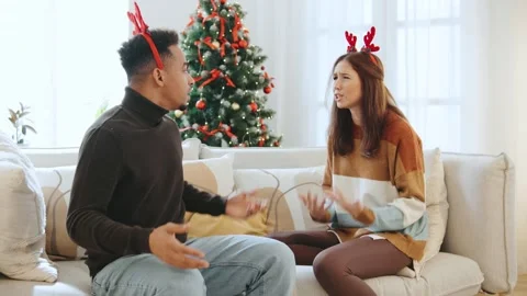 A multi-ethnic couple bickers and fights together on Christmas Day, wearing Stock Footage 319969985