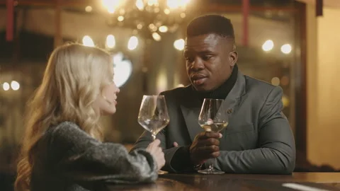 Multi ethnic couple drinking wine in bar in party, clincking glasses, toasting Stock Footage 229541519