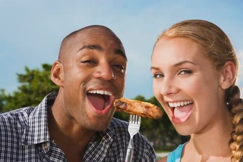 Multi-ethnic couple eating from same fork Stock Photos