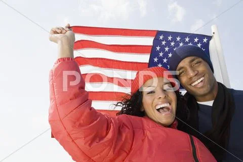 Multi-ethnic couple in front of American flag Stock Photos