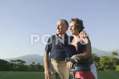 Multi-ethnic couple on golf course Stock Photos