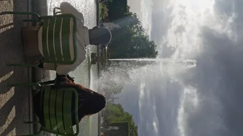 Multi-ethnic. Couple of lovers sits in front of a fountain, look at the fountain Stock Footage 263964885
