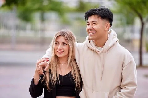 Multi-ethnic couple smiling while walking together outdoors. Foto stock