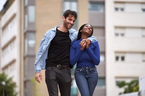 Multi-Ethnic couple smiling while walking on the street together. Foto stock