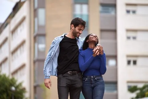 Multi-Ethnic couple smiling while walking on the street together. Foto stock