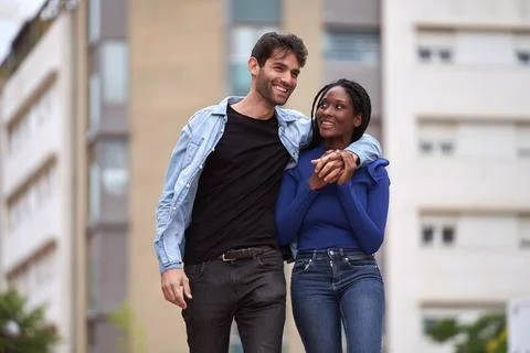 Multi-Ethnic couple smiling while walking on the street together. Foto stock