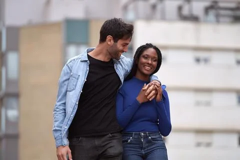 Multi-Ethnic couple smiling while walking on the street together. Foto stock