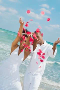Multi-ethnic couple throwing flower petals in air Stock Photos